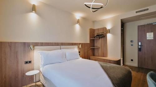 a bedroom with a large white bed in a room at Keystone Hôtel & Spa in Lyon