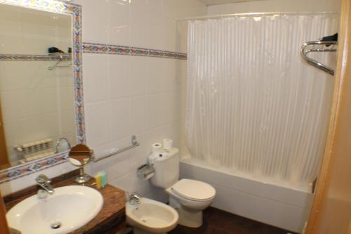 a white toilet sitting next to a bath tub in a bathroom at Hotel Meta in Pas de la Casa