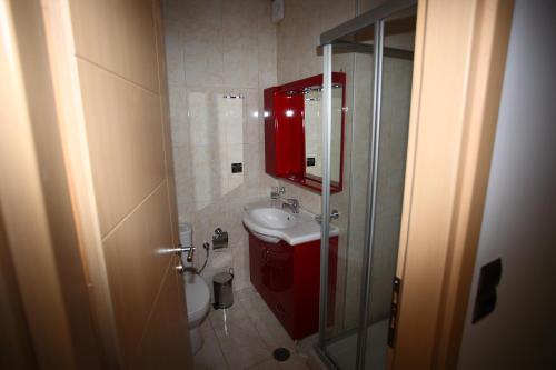 a bathroom with a red sink and a toilet at Villa Constance, Grapevines Villas in Makry Gialos