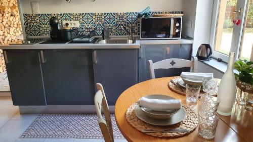 Il comprend une cuisine avec une table en bois et des placards bleus. dans l'établissement Strasbourg dans maison individuelle au calme, à Schiltigheim