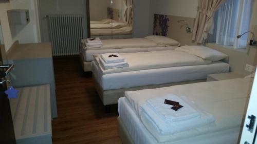 a room with three beds and a mirror at Ristorante Stazione con alloggio in Rivera
