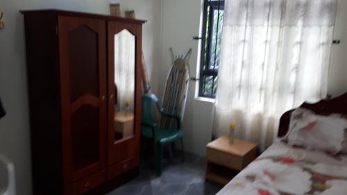 a bedroom with a bed and a cabinet and a chair at Toofan villa in Flic-en-Flac