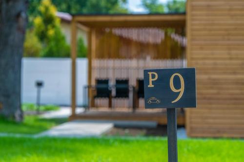 a sign in the grass in front of a house at Zsóry Liget Camping & Resort in Mezőkövesd