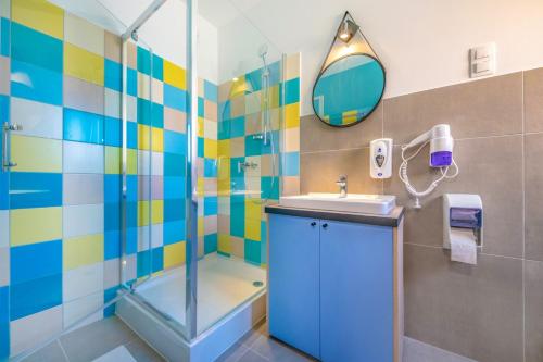 a bathroom with a shower and a sink and a mirror at Zsóry Liget Camping & Resort in Mezőkövesd