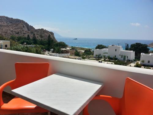 a table and chairs on a balcony with a view of the ocean at Montemar Studios & Apartments in Arkasa