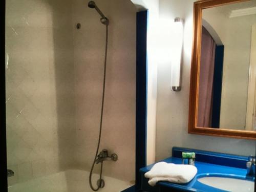 a bathroom with a shower and a sink and a mirror at 2p sur le golf de La Baule 