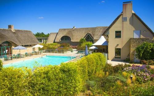 ein Haus mit einem Pool neben einem Gebäude in der Unterkunft 2p sur le golf de La Baule 