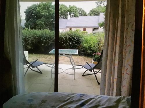 a view of a table and chairs from a window at 2p sur le golf de La Baule 