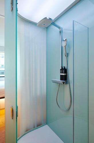 a bathroom with a shower with a glass door at citizenM Washington DC NoMa in Washington