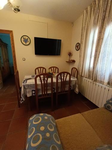 een eetkamer met een tafel en stoelen en een televisie bij La alacena de Jose y Rosi in Güéjar-Sierra