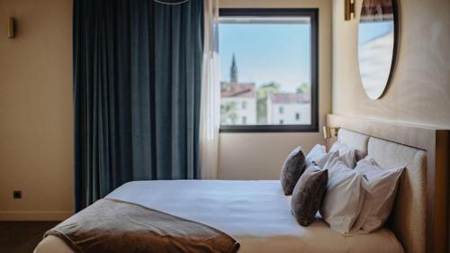 a hotel room with a bed with a window at Keystone Hôtel & Spa in Lyon