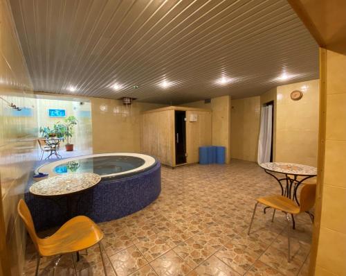 una camera con vasca idromassaggio con due tavoli e sedie di Hotel-Restaurant Smilga a Kėdainiai