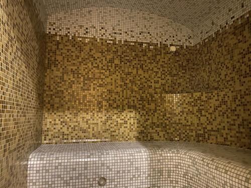 a bathroom with a bed in a tiled wall at Hotel-Restaurant Smilga in Kėdainiai