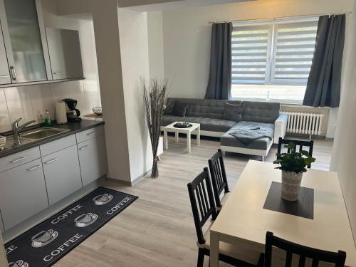 a kitchen and living room with a table and a couch at Ferienwohnung am Park in Holzminden