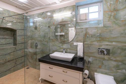 La salle de bains est pourvue d'un lavabo et d'une douche. dans l'établissement StayVista at Springfield with Scenic Lawn, à Kasauli