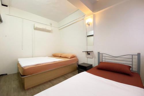 Habitación pequeña con 2 camas y espejo. en SPOT ON 90587 The Space Inn, en Kuala Terengganu