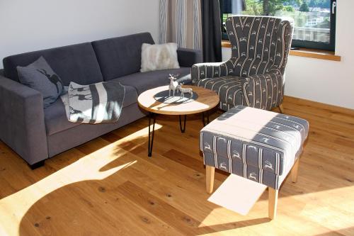 a living room with a couch and a table at Bergzauber Alpin Suites - Skipiste - Private Sauna in Bolsterlang