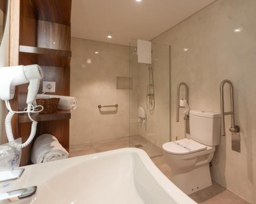 a bathroom with a bath tub and a toilet at Casa dos Romeiros in Santa Bárbara