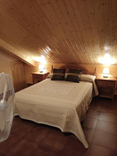 ein Schlafzimmer mit einem großen Bett mit zwei Nachttischen in der Unterkunft La alacena de Jose y Rosi in Sierra Nevada