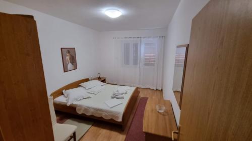 a small bedroom with a bed in a room at Apartman Podgora with beautiful sea view in Podgora