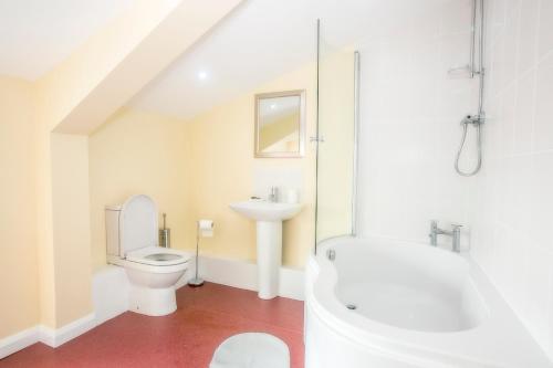 a white bathroom with a toilet and a sink at The Brown Horse Hotel in Wolsingham