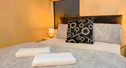 een slaapkamer met een bed met 2 kussens erop bij Manchester Old Trafford Apartment in Manchester