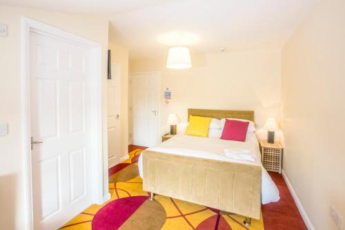 a bedroom with a bed with colorful pillows at The Brown Horse Hotel in Wolsingham