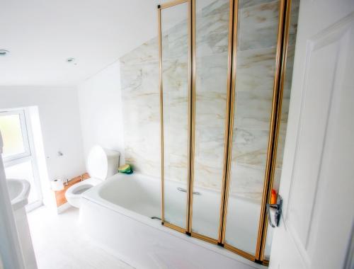 a white bathroom with a tub and a toilet at The Brown Horse Hotel in Wolsingham