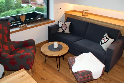 a living room with a couch and a table at Bergzauber Alpin Suites - Skipiste - Private Sauna in Bolsterlang