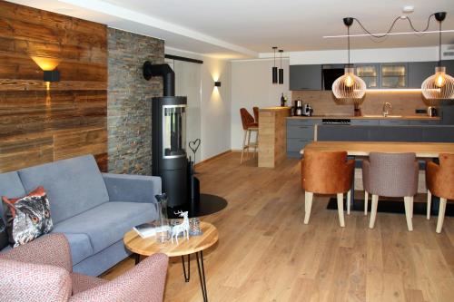 a living room with a blue couch and a kitchen at Bergzauber Alpin Suites - Skipiste - Private Sauna in Bolsterlang