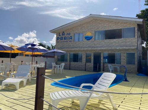 patio z krzesłami, basenem i budynkiem w obiekcie Pousada Lá Na Praia w mieście São José da Coroa Grande