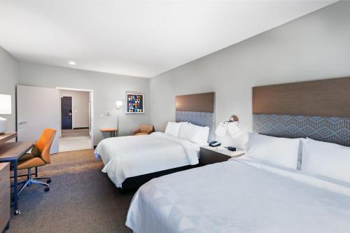 a hotel room with two beds and a desk at Holiday Inn Lubbock South, an IHG Hotel in Lubbock