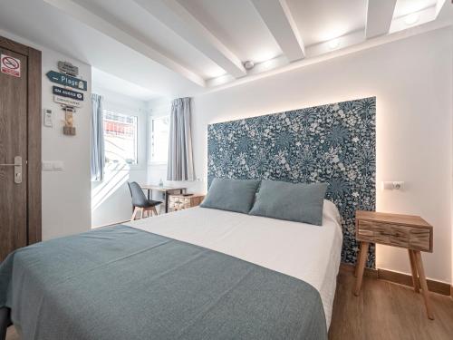 Un dormitorio con una cama con una pared de acento azul en La Isla , tu hogar en Torre del Mar. en Torre del Mar