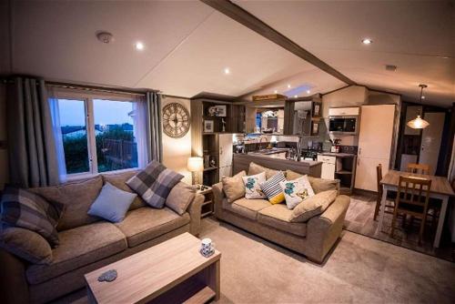 ein Wohnzimmer mit 2 Sofas und einer Küche in der Unterkunft Holly in Paignton