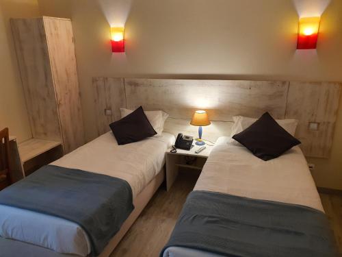 2 camas en una habitación con 2 lámparas y teléfono en Hotel Vila Raia, en Idanha-a-Nova