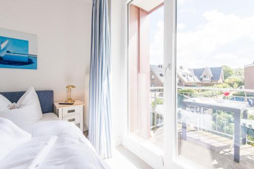 een slaapkamer met een bed en een groot raam bij Haus Hauke Whg 8 in Westerland