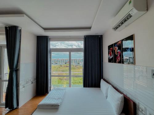 Zimmer mit einem Bett und einem großen Fenster in der Unterkunft Khách Sạn Cốc Cốc in Rạch Giá