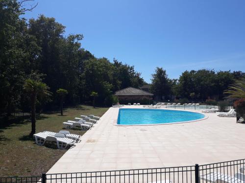 une grande piscine avec des chaises longues à côté dans l'établissement House near the ocean and forest, à Soulac-sur-Mer