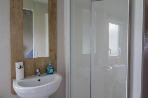 a bathroom with a white sink and a shower at Beautiful 6 Berth Caravan For Hire At Central Beach Park In Kent Ref 57018b in Leysdown-on-Sea