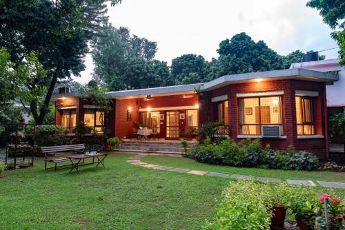 mały domek z trawnikiem przed nim w obiekcie SaffronStays Doon Garden Villa - near Doon School and Mall Road w mieście Dehradun