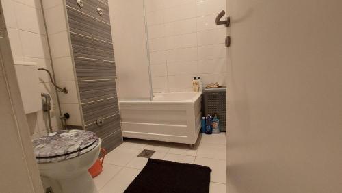 een badkamer met een toilet, een bad en een wastafel bij White Pearl Residence in Sarajevo