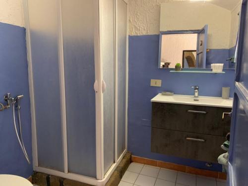 a blue bathroom with a sink and a mirror at Cactus b&b Le casette di Marilena in Pantelleria