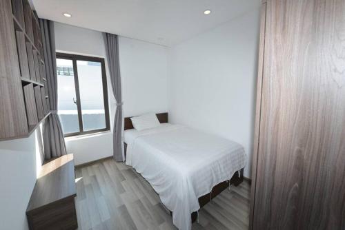 a white bedroom with a bed and a window at Two-Bedrooms - POOL SEA VIEW - 6A - BLUE SEA APARTMENT in Da Nang