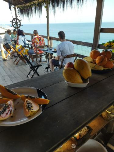 uma mesa com pratos de fruta em cima em Pousada Marambaia Café em Barra de Guaratiba