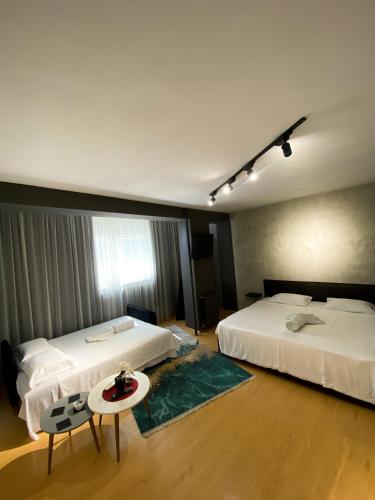 una habitación de hotel con dos camas y una mesa en MT Apartments Skopje, en Skopje