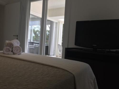 a bedroom with a bed with a television and towels at Green Park in Punta del Este