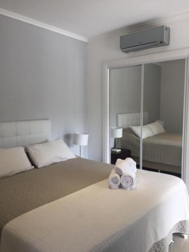 a bedroom with a bed with two rolled towels on it at Green Park in Punta del Este