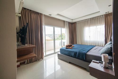 uma mulher deitada numa cama num quarto em Shiba Guesthouse em South Pattaya