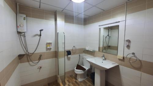 a bathroom with a shower and a toilet and a sink at Shiba Guesthouse in Pattaya South