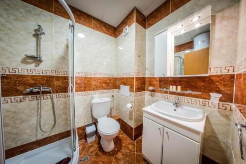 uma casa de banho com um WC, um chuveiro e um lavatório. em Privilege Fort beach Apartman Sveti Vlas 61m2 em Elenite